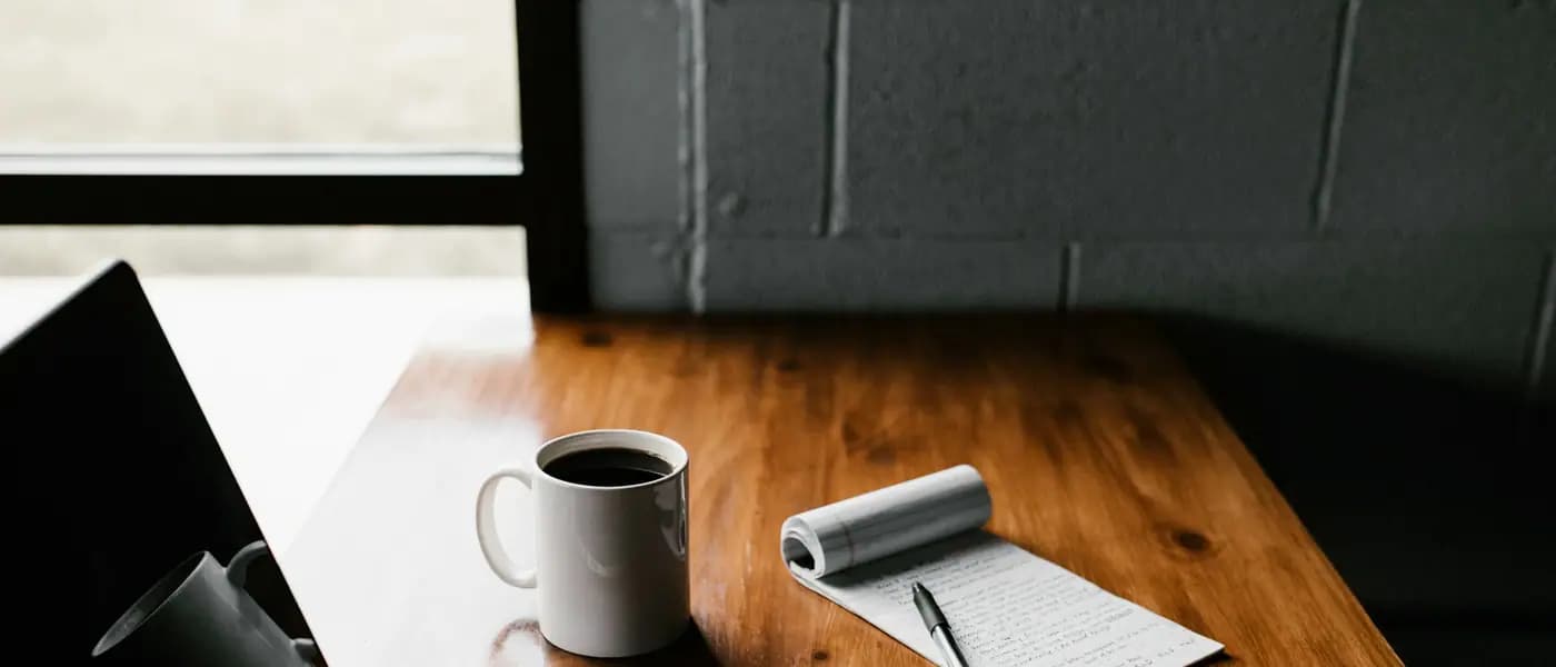 Laptop and notebook on a wooden desk for content marketing services