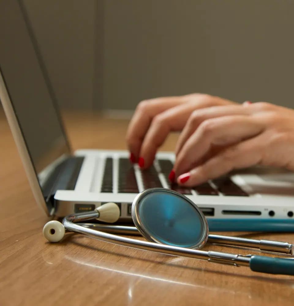 Stethoscope beside a laptop representing doctor marketing services