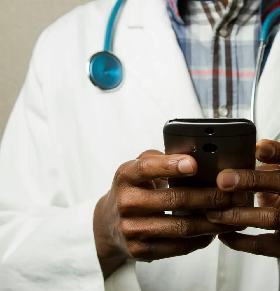 Doctor in a white coat using a smartphone representing doctor PR