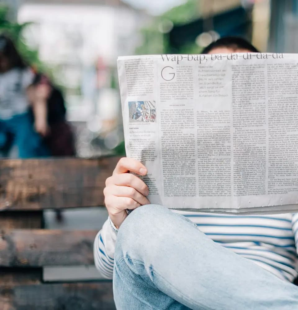 Person reading a newspaper representing PR services in India